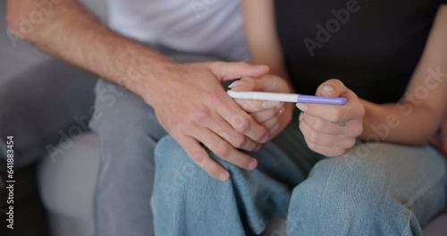 Closeup, hands and a couple with pregnancy test results, comfort and reading together. Family, support and a man and woman with information on a baby, pregnant and care on the sofa for infertility