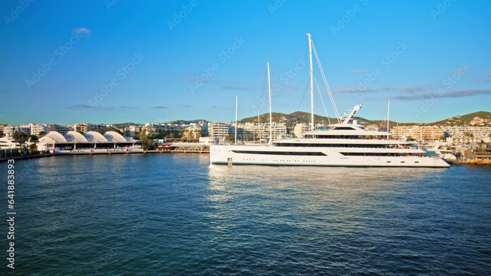 Luxury yachts and boats by Eivissa Harbour Port with buildings in background. Big yachts of millionaires and billionaires enjoying vacation on the Ibiza Island in Spain. Luxury yachts and boats by Eivissa Harbour Port with buildings in background. Big yachts of millionaires and billionaires enjoying vacation on the Ibiza Island in Spain.