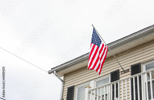 vibrant US flag waves against a clear sky, evoking American pride on a sunny day. Symbolizes patriotism, unity, and national celebration