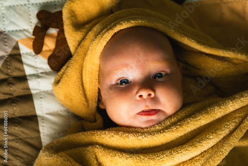 A newborn baby wrapped in a towel after bathing. The concept of childhood and infant care