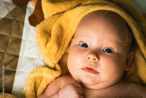 A newborn baby wrapped in a towel after bathing. The concept of childhood and infant care