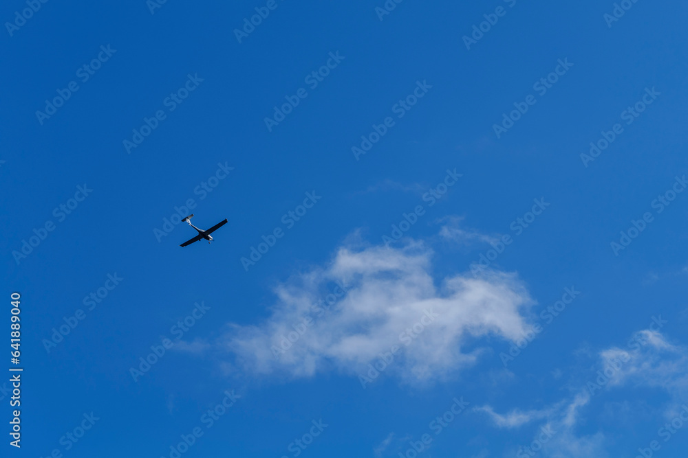 Small white cessna single propeller plane flying in a clear blue sky . High quality photo Small white cessna single propeller plane flying in a clear blue sky . High quality photo