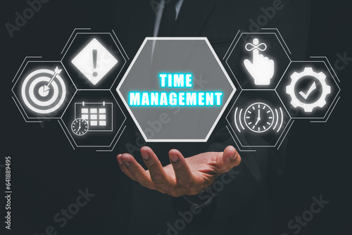 Time management concept, Businessman hand holding time management icon on virtual screen.