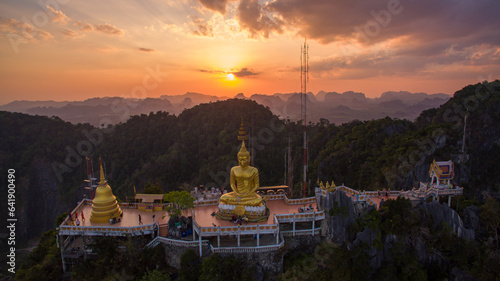 .The golden buddha on the top of high mountain. .It is more interesting temple complexes in Krabi Thailand, .as the monks live and worship within a maze of natural caves in an overgrown jungle. © Narong Niemhom