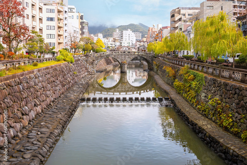 Nagasaki, Japan - Nov 29 2022: Meganebashi Bridge is the most remarkable of several stone bridges. The bridge gets its name from the resemblance of spectacles when reflected in the river water photo