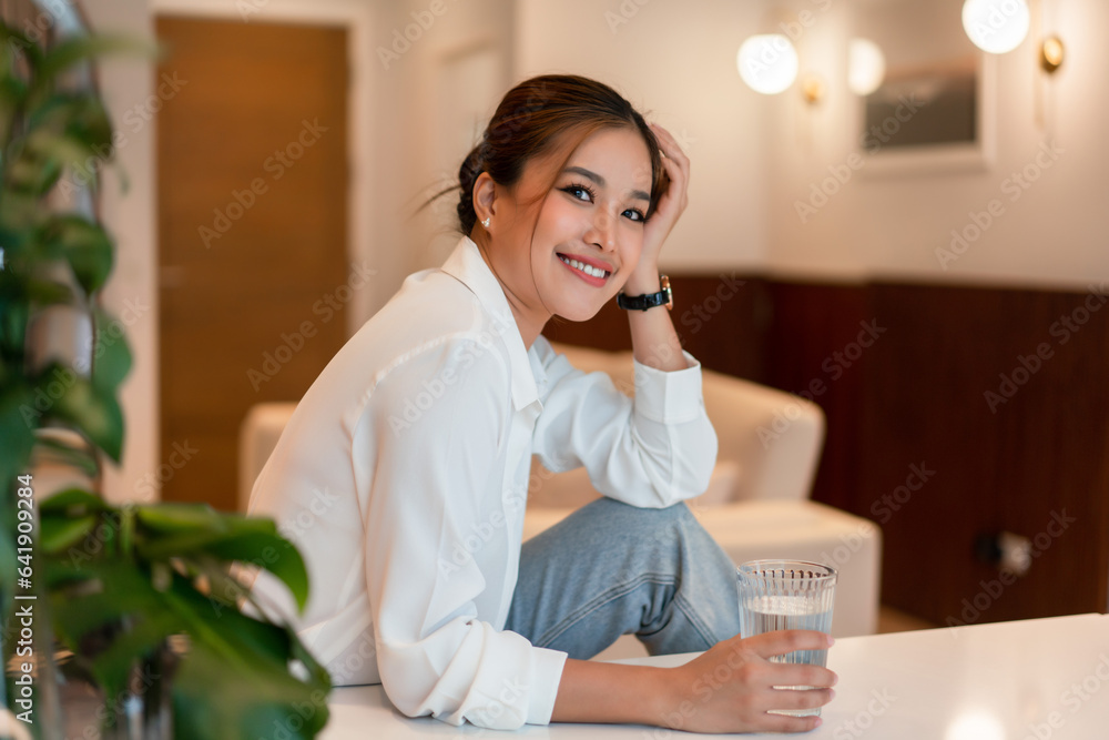 Female entrepreneur drinking water while relaxation after working business project in home office Female entrepreneur drinking water while relaxation after working business project in home office