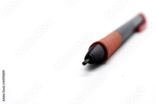 a mechanical pencil with red and black colors photographed on the isolated white background