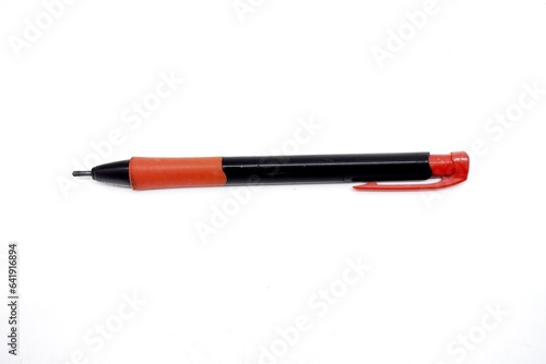 a mechanical pencil with red and black colors photographed on the isolated white background