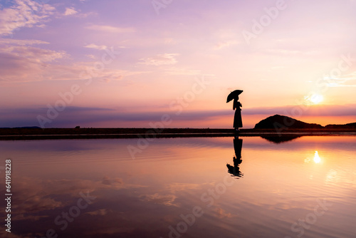夕暮れの父母ヶ浜を歩く女性