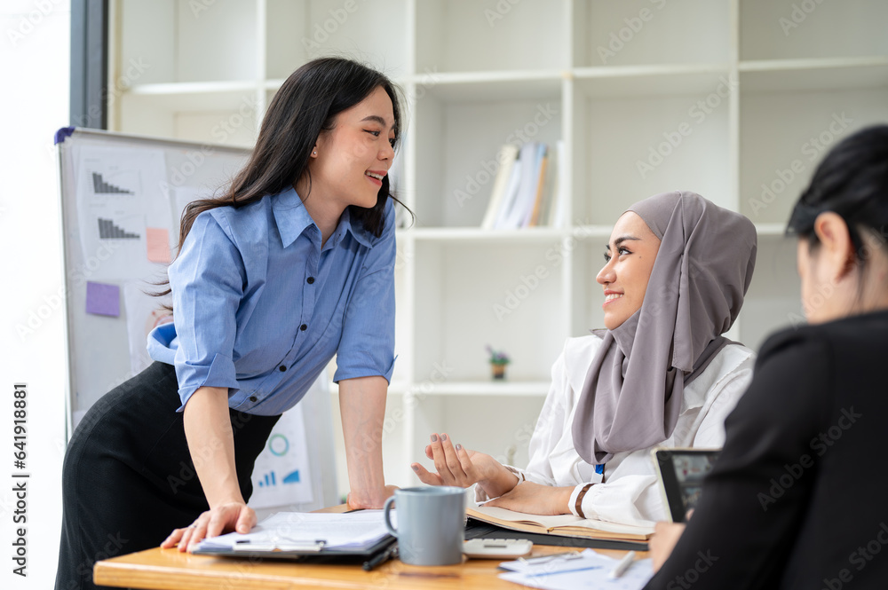 A beautiful Asian businesswoman is discussing ideas and brainstorming with her diverse colleagues A beautiful Asian businesswoman is discussing ideas and brainstorming with her diverse colleagues