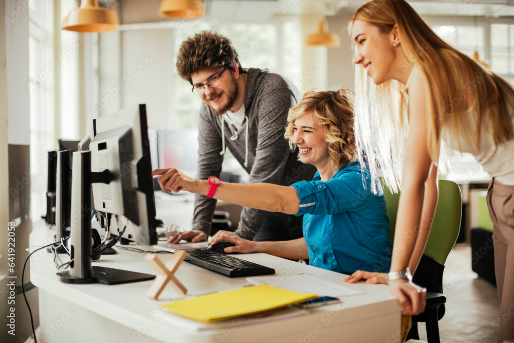 Young man and women using the computer in a office