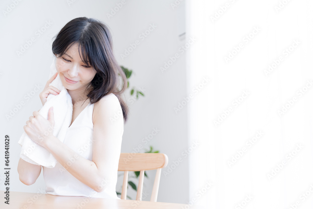 タオルで首を拭く日本人女性 タオルで首を拭く日本人女性