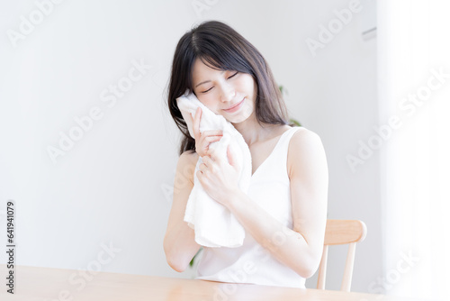 タオルで顔を拭く日本人女性