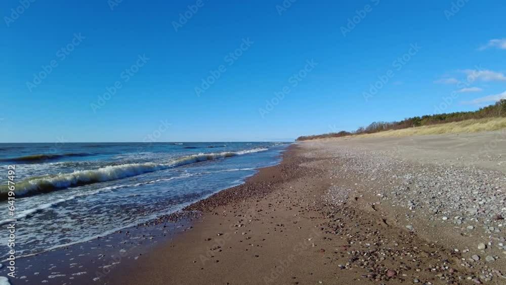 Calm beach walking on Baltic sea shore on sunny day Calm beach walking on Baltic sea shore on sunny day