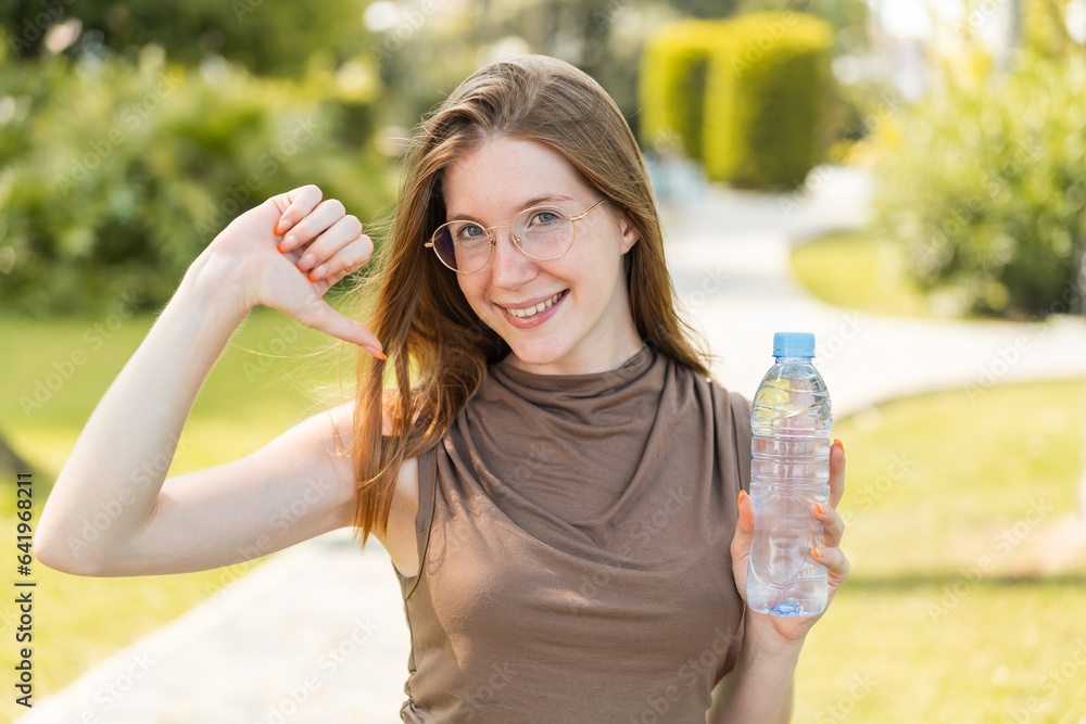 French girl with glasses holding a bottle of water at outdoors proud and self-satisfied French girl with glasses holding a bottle of water at outdoors proud and self-satisfied