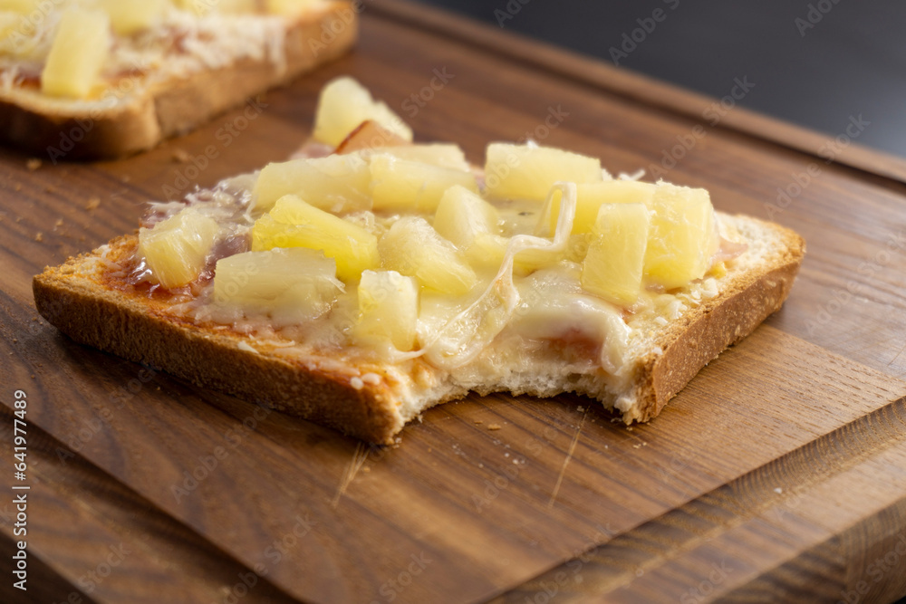 toast with ham and pineapple on a wooden background. sandwich. mini pizza. top view