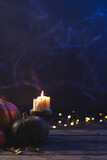 Vertical image of pumpkins and candle with copy space on dark background