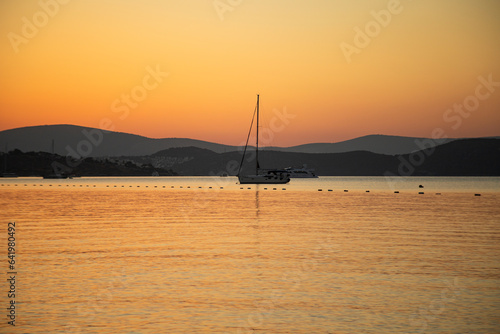 beautiful sunrise over Bodrum. clear sky and orange sun. boats sailiing on the sea