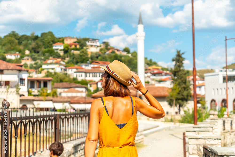A young woman walking through the town of Berat in Albania on vacation, the city of a thousand windows