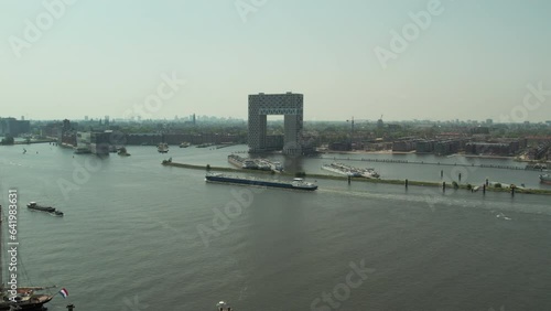 Barge Cruising In The IJ River Passing By Hotel Pontsteiger In Amsterdam, Netherlands. - aerial
 photo