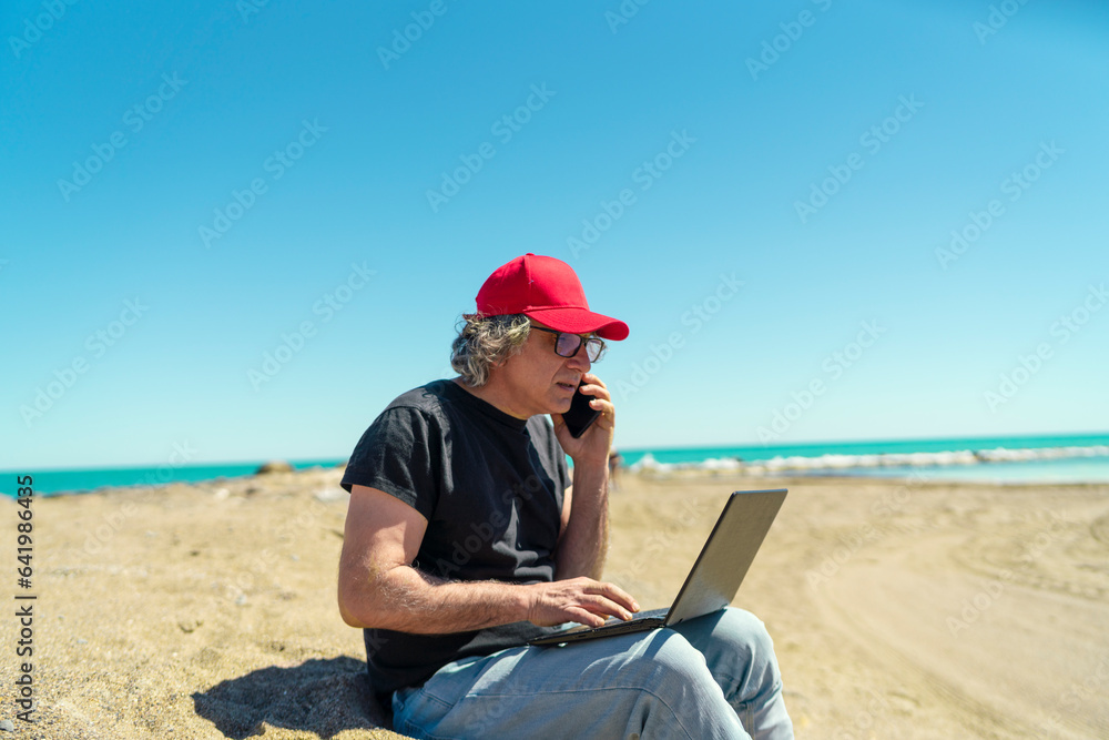 Seaside Productivity: A 50-Year-Old Man Working with His Laptop by the Beach