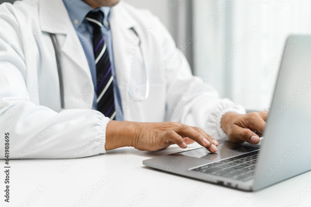 Medical Technology Concepts. Medical students use laptop to search for information in a modern office in the morning at the desk.
