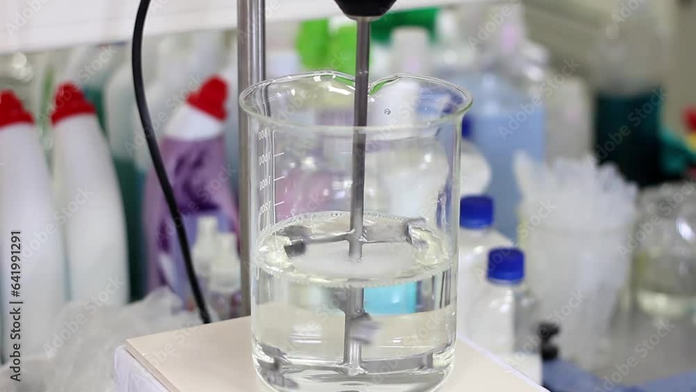 Laboratory Overhead Stirrer Mixes Solution in Lab Beaker. Transparent Liquid Being Stirred in an Experiment. Research and Development. Laboratory Overhead Stirrer Mixes Solution in Lab Beaker. Transparent Liquid Being Stirred in an Experiment. Research and Development.