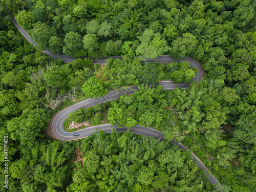 Aerial view road in the middle forest, Top view road going through green forest adventure, Ecosystem ecology healthy environment road trip travel net zero © Sarawin
