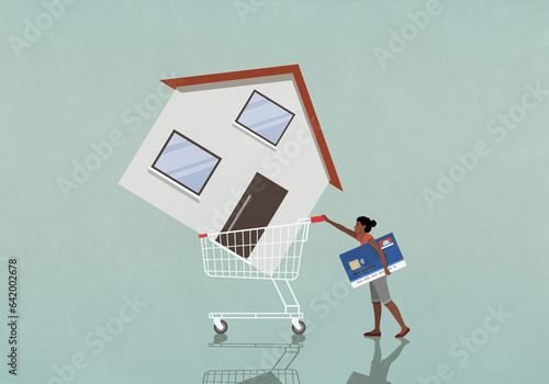 Woman with credit card pushing house in shopping cart
 photo