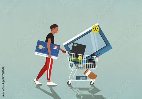 Male consumer with credit card pushing shopping cart with technology merchandise
 photo