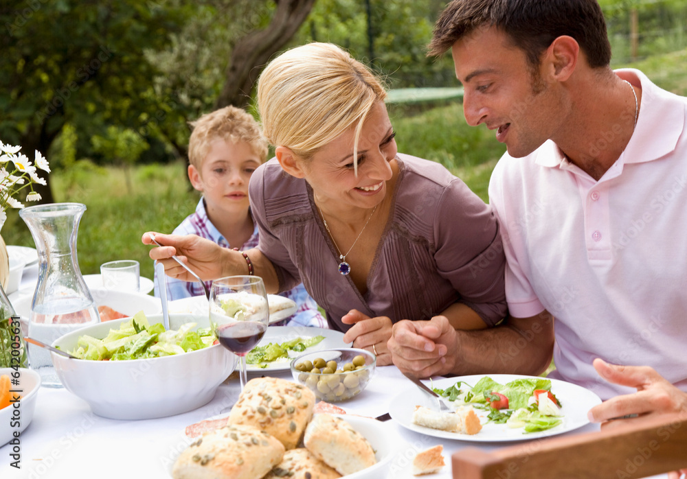 Couple and young boy having lunch outside
Couple and young boy having lunch outside