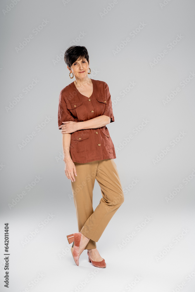 stylish middle aged woman in linen jacket and beige pants on grey, autumn style, full length stylish middle aged woman in linen jacket and beige pants on grey, autumn style, full length