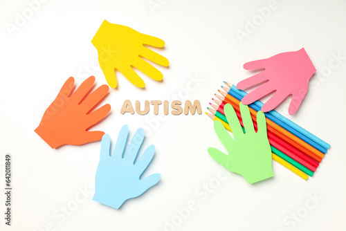 Multicolored paper hands with pencils on white background. World autism day concept