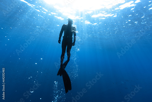 Freediver Swimming in Deep Sea With Sunrays. © Jag_cz