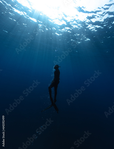 Freediver Swimming in Deep Sea With Sunrays. © Jag_cz