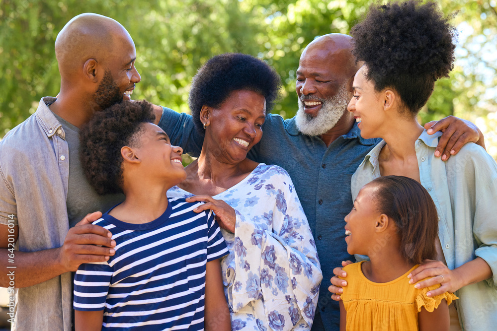 Portrait Of Multi-Generation Family Standing Outdoors In Garden Or Countryside Smiling At Camera Portrait Of Multi-Generation Family Standing Outdoors In Garden Or Countryside Smiling At Camera
