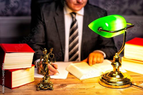 office of a lawyer with statue of Lady Justice, goddess Justitia, on the desk photo