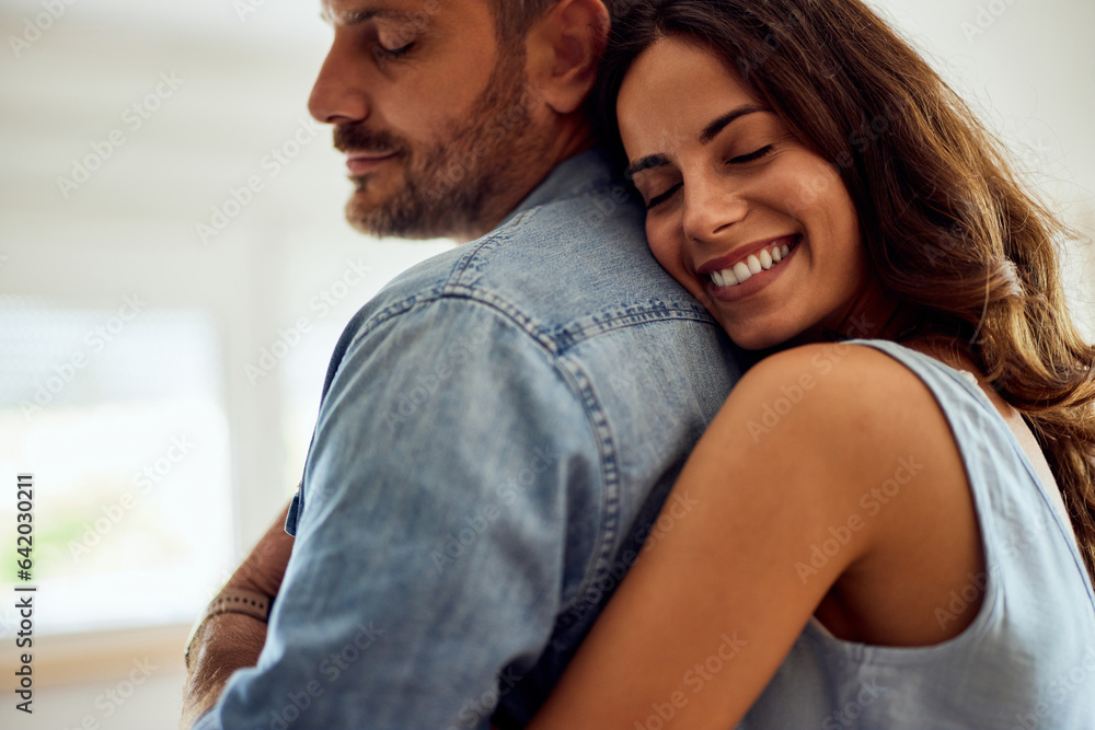 A close-up of a smiling woman giving her boyfriend a hug from the back. A close-up of a smiling woman giving her boyfriend a hug from the back.