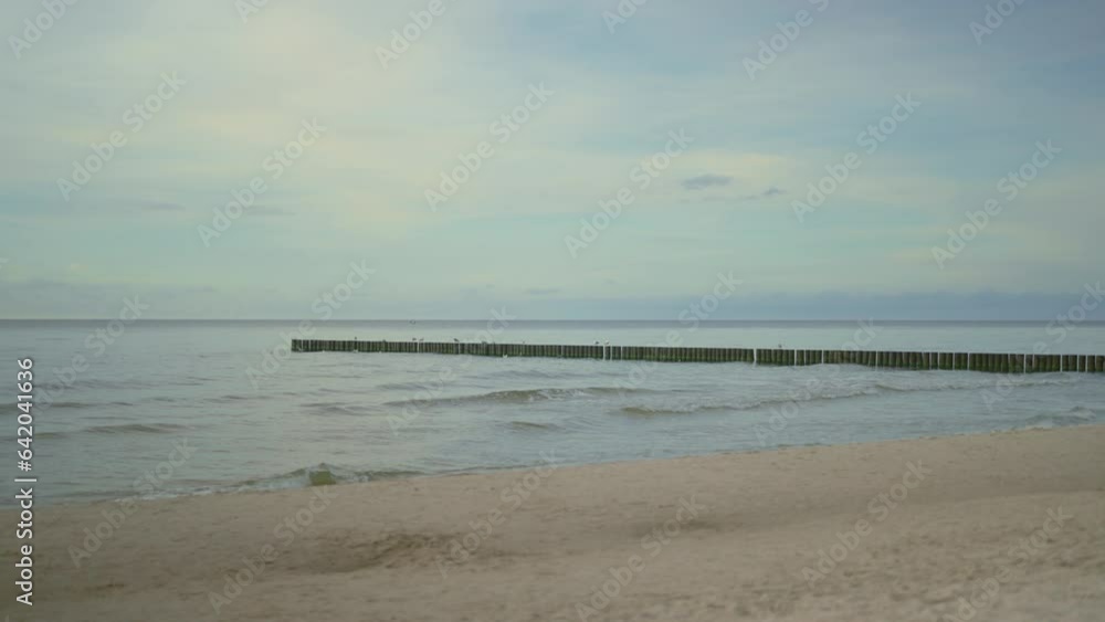 Lovely beach at the coastline. Waves crashing at groyne Lovely beach at the coastline. Waves crashing at groyne