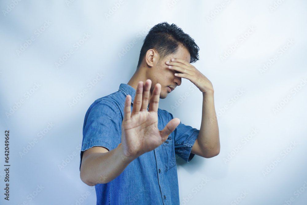 Attractive young asian man on isolated white background scared and terrified with frightened expression stop gesturing with hands, screaming in shock. Panic concept. Attractive young asian man on isolated white background scared and terrified with frightened expression stop gesturing with hands, screaming in shock. Panic concept.