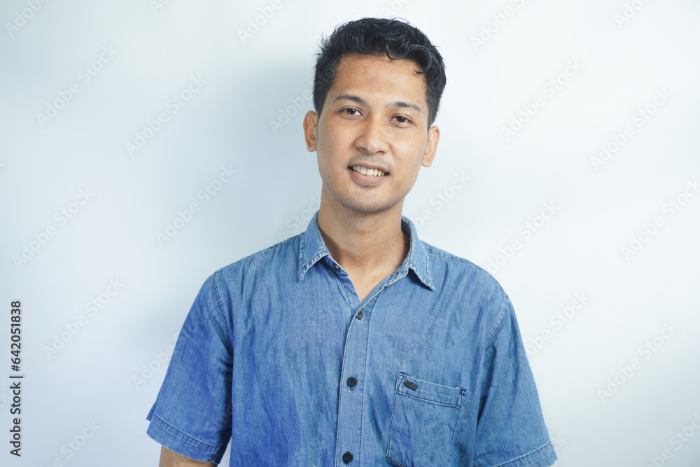 Young handsome man wearing blue shirt over white background happy face smiling looking at the camera. Positive person. Young handsome man wearing blue shirt over white background happy face smiling looking at the camera. Positive person.