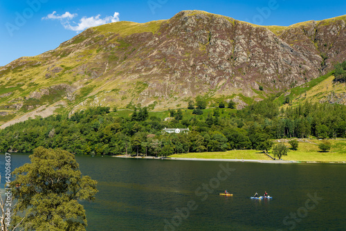 Fototapeta Naklejka Na Ścianę i Meble -  Kayaks and paddleboards on a calm, peaceful lake surrounded by tall mountains (Buttermere, Lake Distrtict)