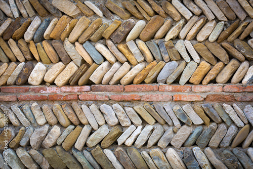 colored river pebbles round stone wall background close up