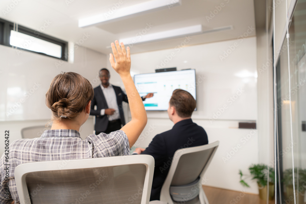 Obraz premium Businessman giving presentation to colleagues in conference room, Multiethnic group of businesspeople having meeting in modern office.