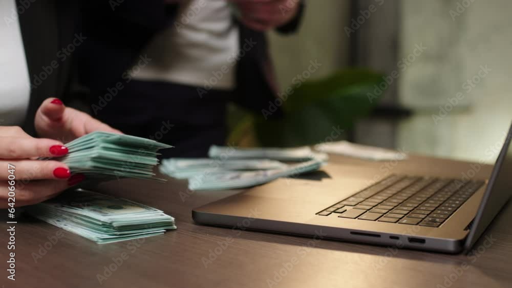 Business partners work at night at a laptop and count money for a planned deal. The concept of financial expenses, profit and business. Business partners work at night at a laptop and count money for a planned deal. The concept of financial expenses, profit and business.