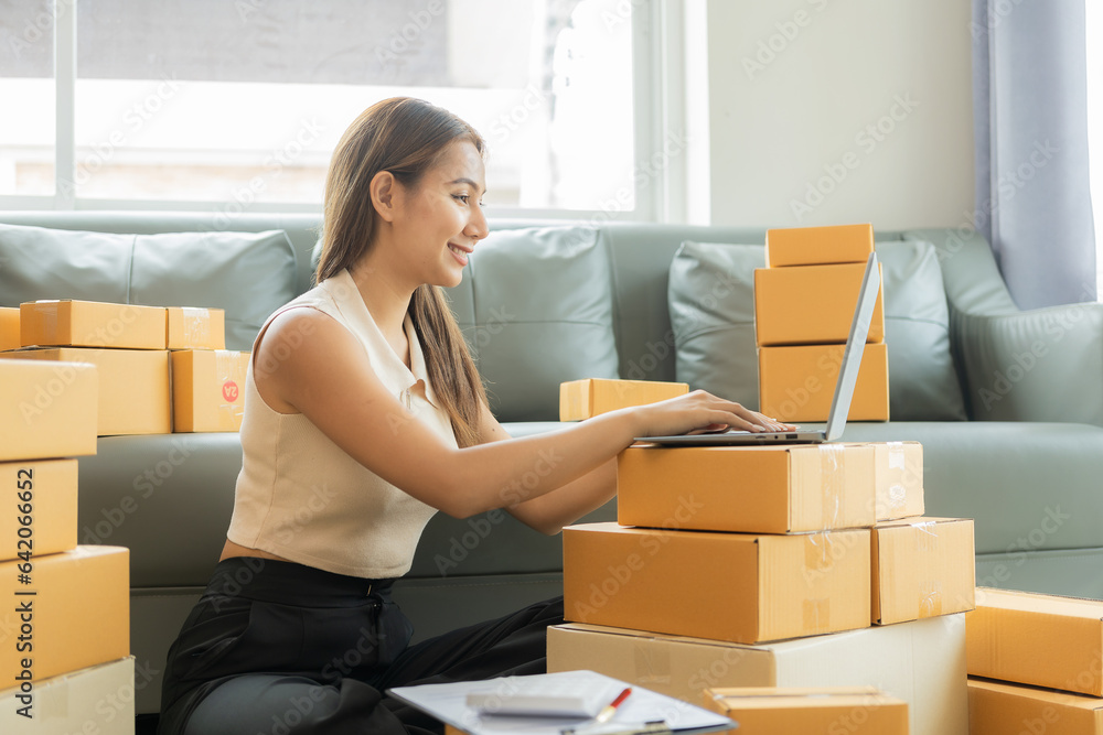 A small business entrepreneur, start-up or freelance Asian woman working with parcel boxes and laptops, a successful Asian woman with packaging boxes, her online marketing and shipping. A small business entrepreneur, start-up or freelance Asian woman working with parcel boxes and laptops, a successful Asian woman with packaging boxes, her online marketing and shipping.