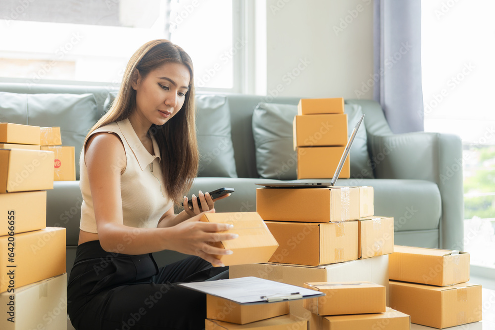 A small business entrepreneur, start-up or freelance Asian woman working with parcel boxes and laptops, a successful Asian woman with packaging boxes, her online marketing and shipping. A small business entrepreneur, start-up or freelance Asian woman working with parcel boxes and laptops, a successful Asian woman with packaging boxes, her online marketing and shipping.