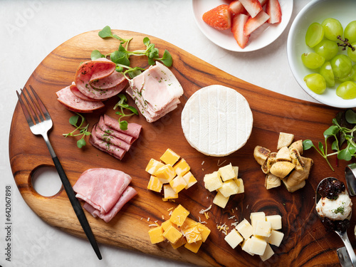 A variety of cube cheese, raw ham, and sweet desserts