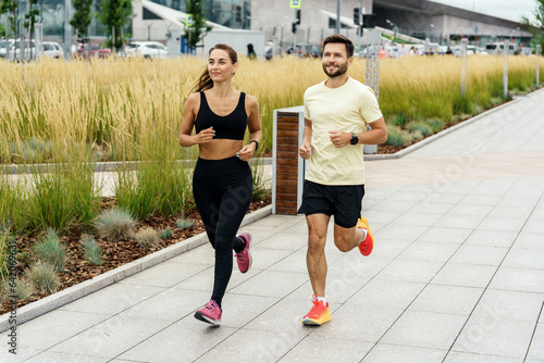 Personal trainer for running and client fitness training in the fresh air. A woman and a man are friends in sportswear for sports. People use fitness watches and running shoes. t