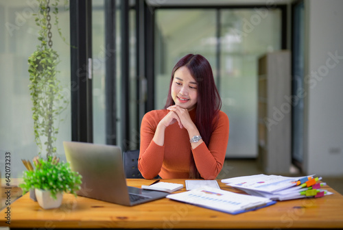 Businesswoman working attentively in front of laptop.Document review, analysis, and planning